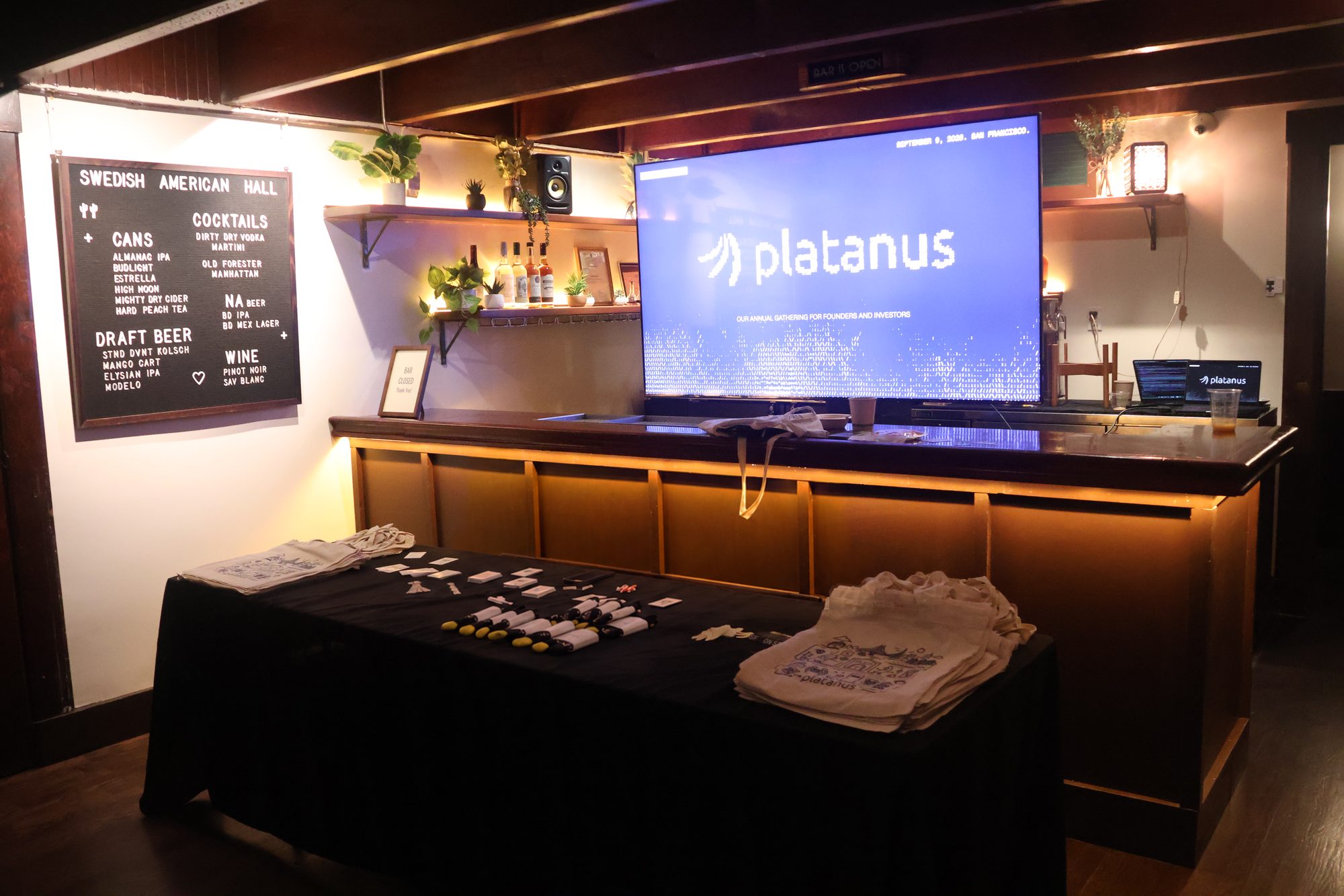 Swedish American Hall bar set up for conference registration with a Platanus screen and swag table