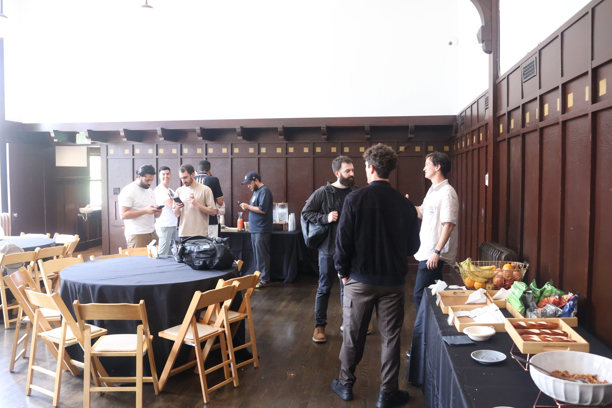 Attendees networking by a catering and coffee station at a corporate event venue in San Francisco
