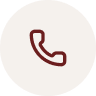 Icon of a telephone handset in maroon color.